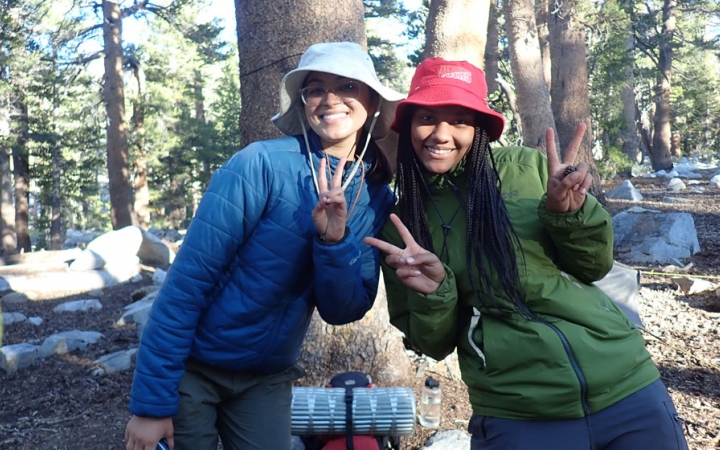 two students smile and give peace signs on a backpacking trip for bipoc teens with outward bound
